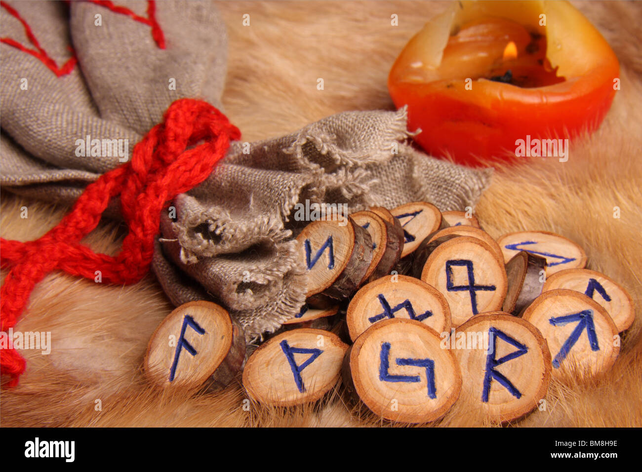 Runes with pouch and candle on the fur Stock Photo - Alamy