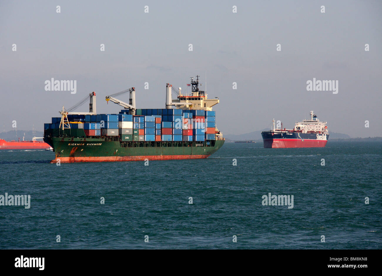 container ship and cargo ships anchored in outer sea Stock Photo