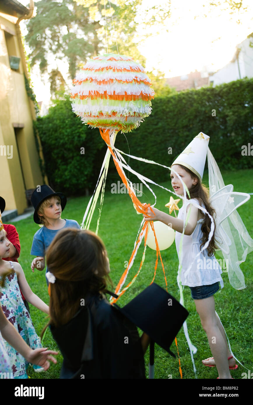 Children pulling streamers attached to pull string pinata Stock