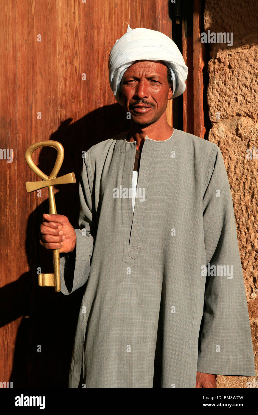 Egyptian man holding the entrance key (Ankh) to the Temple of Ramesses II at Abu Simbel, Egypt Stock Photo