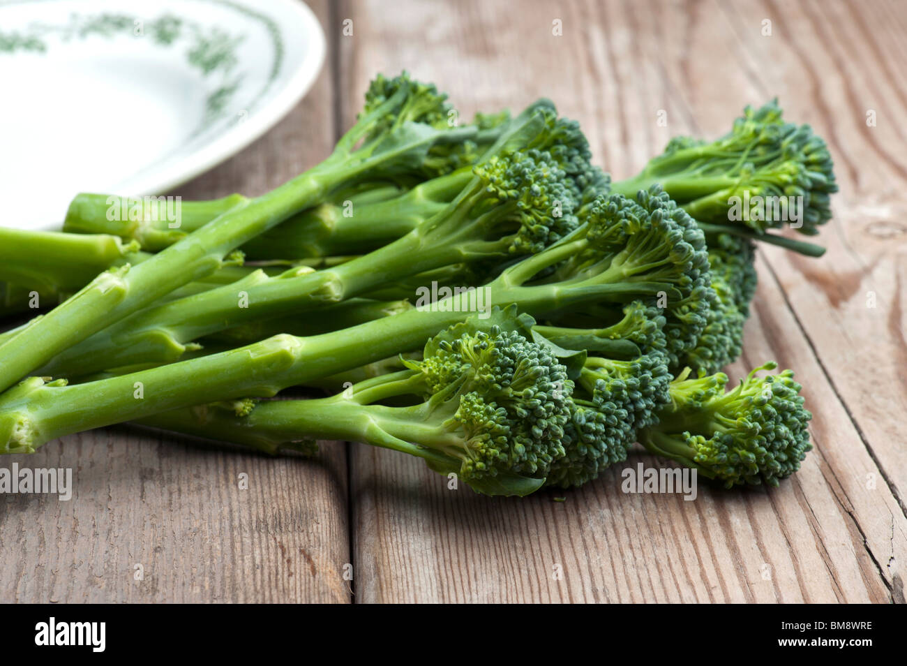 Fresh Tenderstem Broccoli Laid On A Wooden Kitchen Table Stock Photo