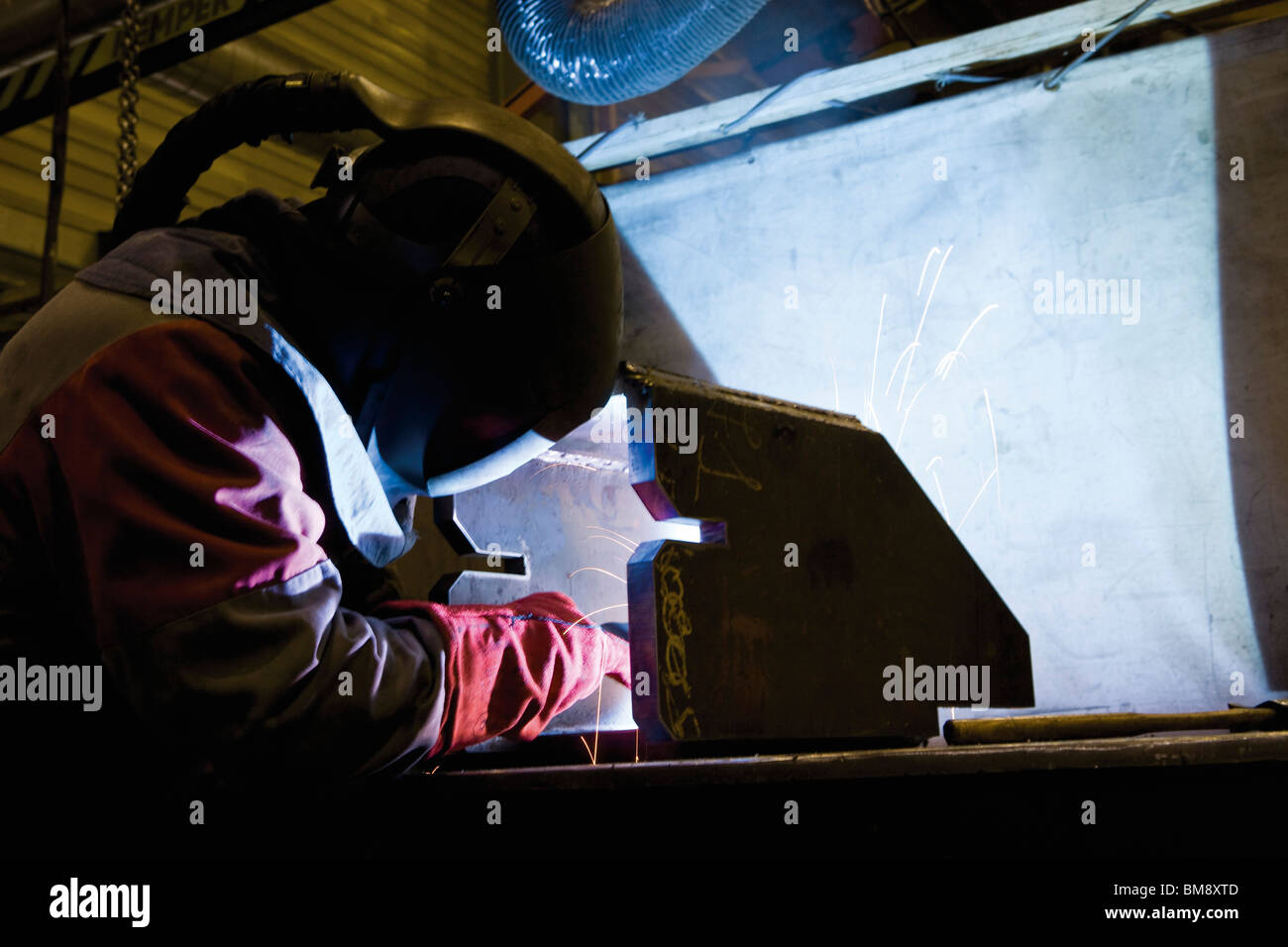 Coated textile plant, maintenance workshop, welder performing arc welding Stock Photo