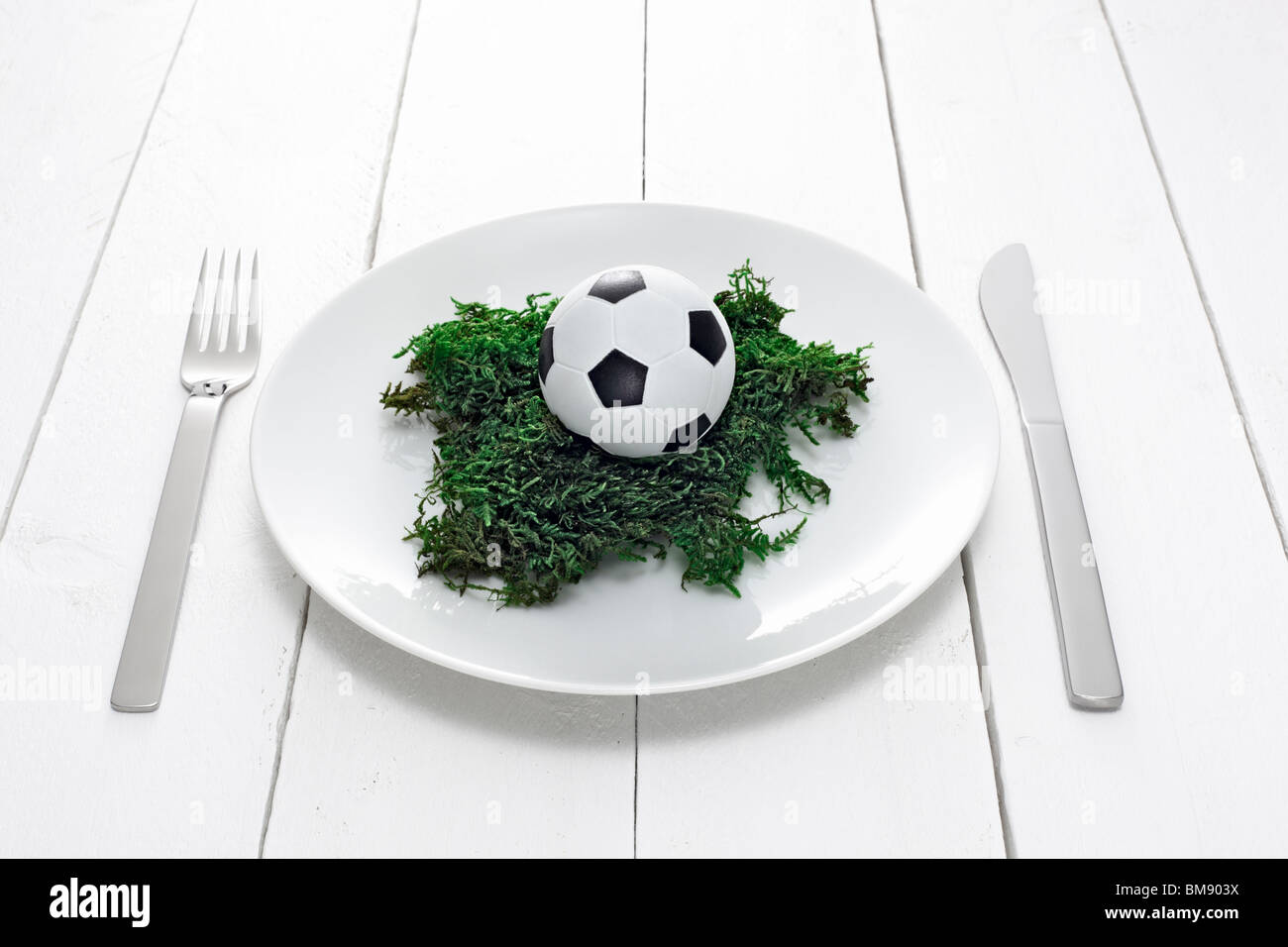 Teller mit Minifussball auf Moos Stock Photo