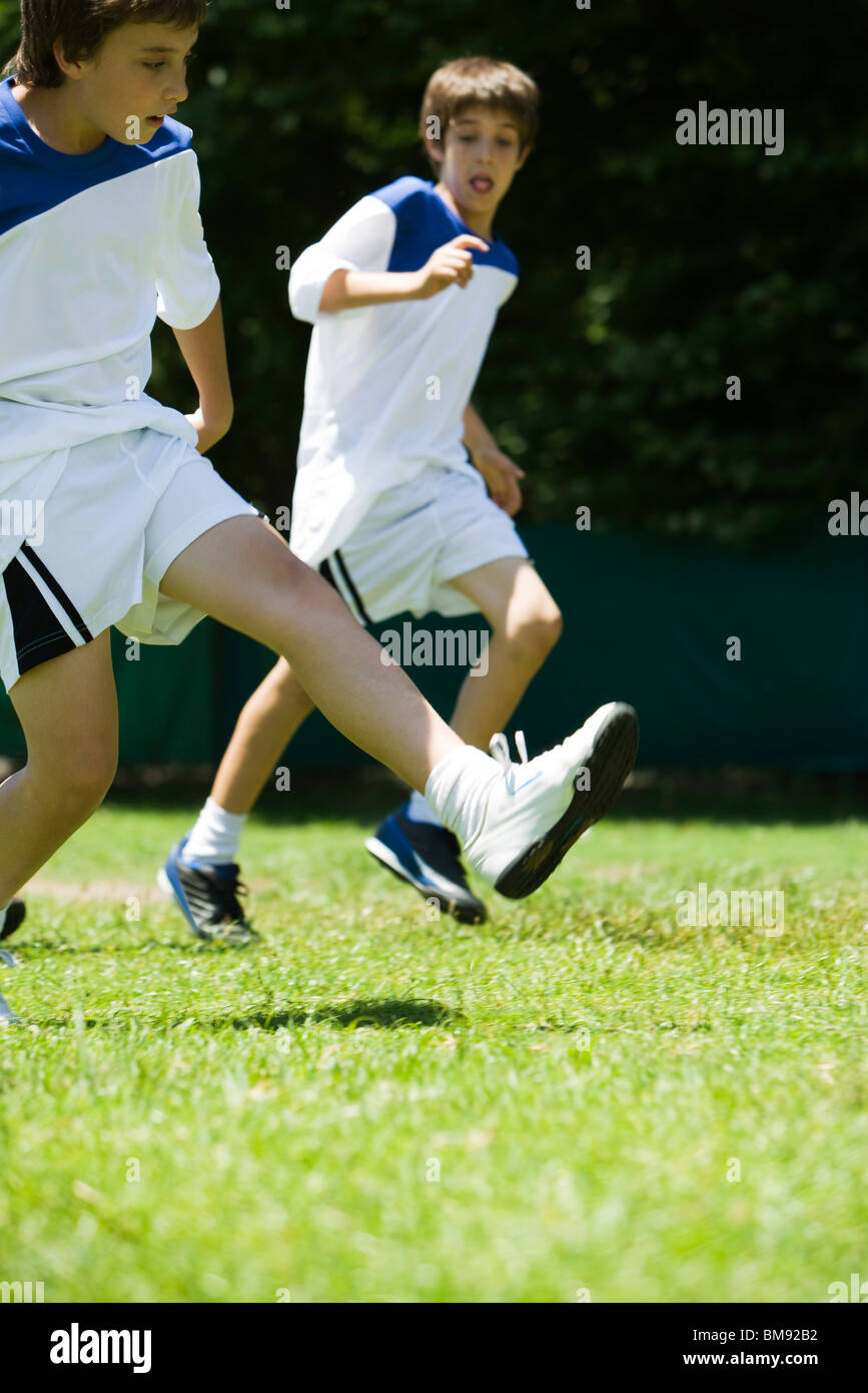 Boys running on soccer field Stock Photo Alamy