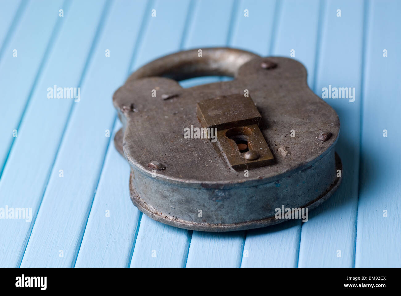 Old rusty lock on blue wooden background Stock Photo