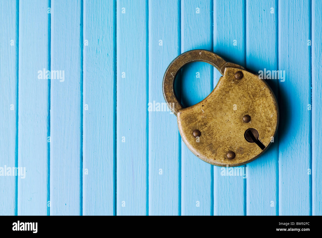 Old fashioned padlock on a blue wooden background Stock Photo