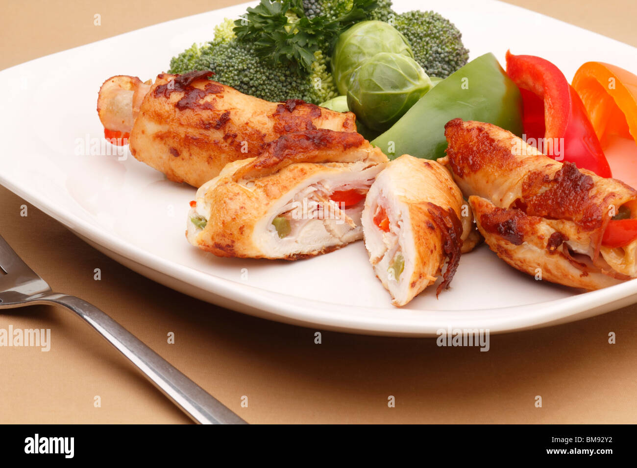 Chicken rolls and fresh vegetables on plate Stock Photo