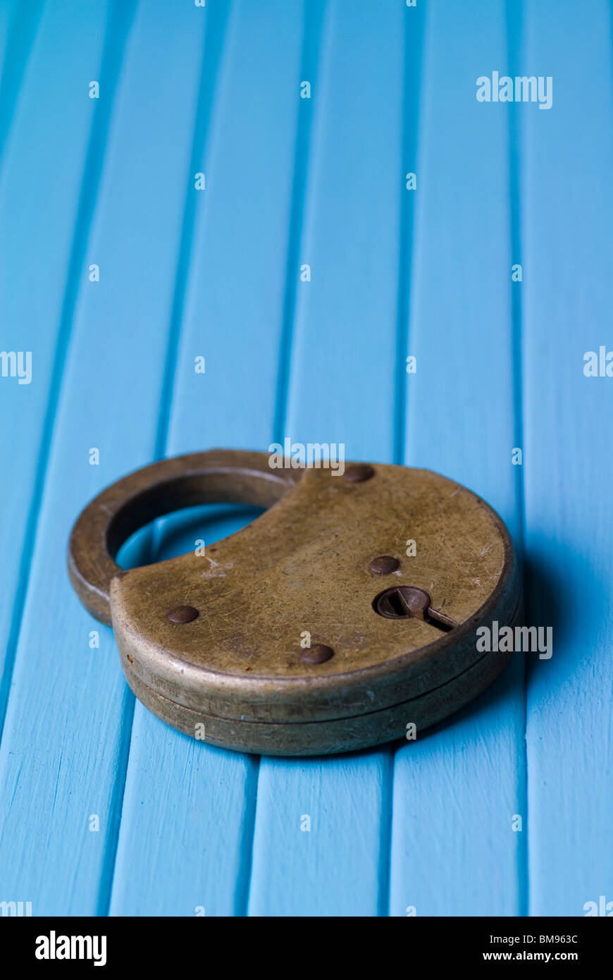 Old fashioned padlock on a blue wooden background Stock Photo