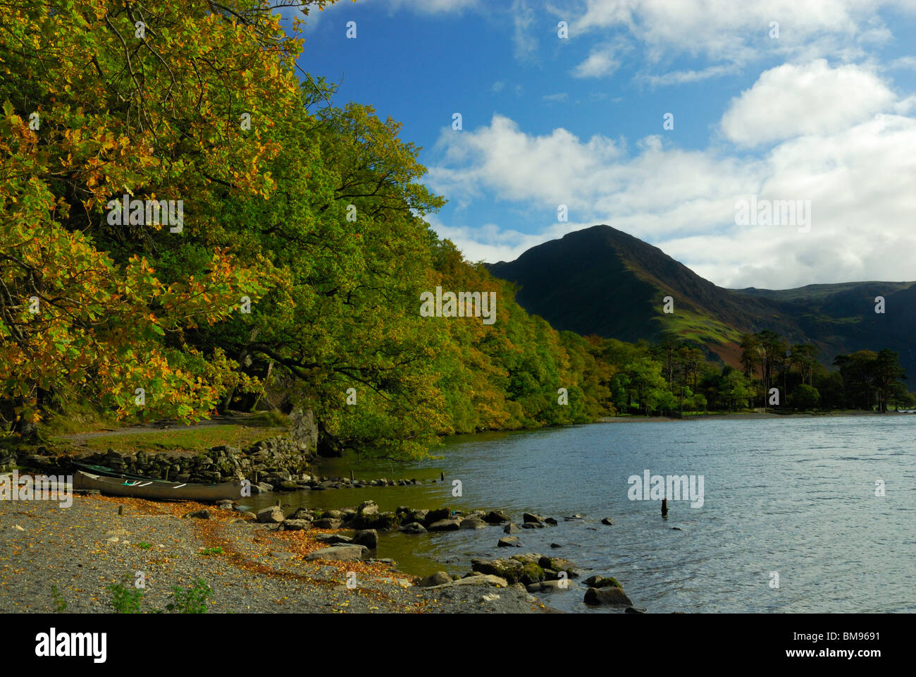 View of Fleetwith Pike from the north shore of lake Buttermere on a sunny autumn day with a canoe in the foreground. Stock Photo
