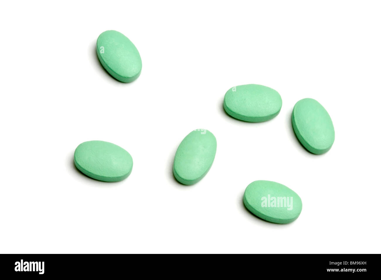 Green pills isolated on white background Stock Photo - Alamy