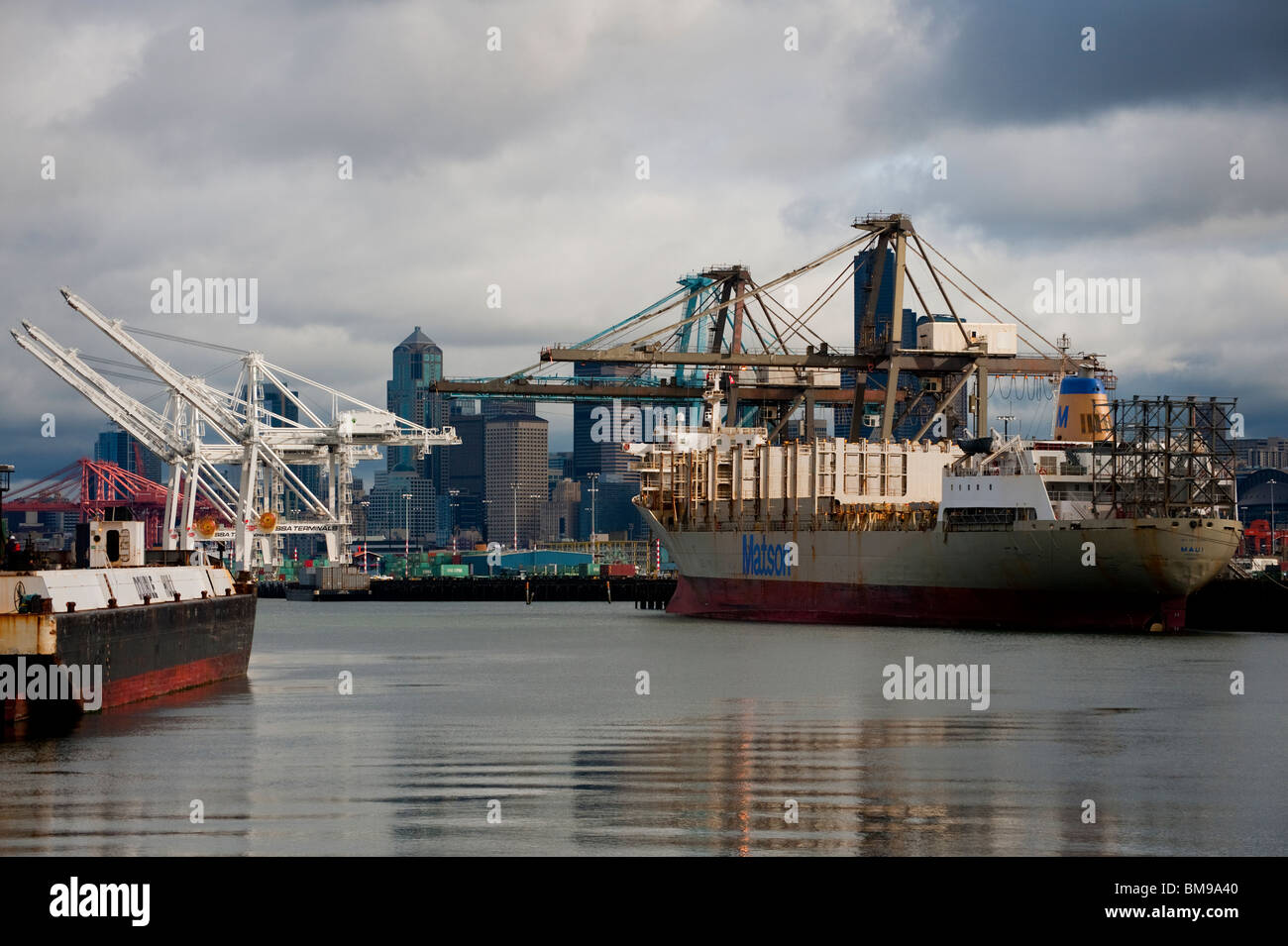 Port of Seattle, Seattle, Washington, USA. Cargo ships are loaded with containers by huge cranes to travel to far ports of call. Stock Photo