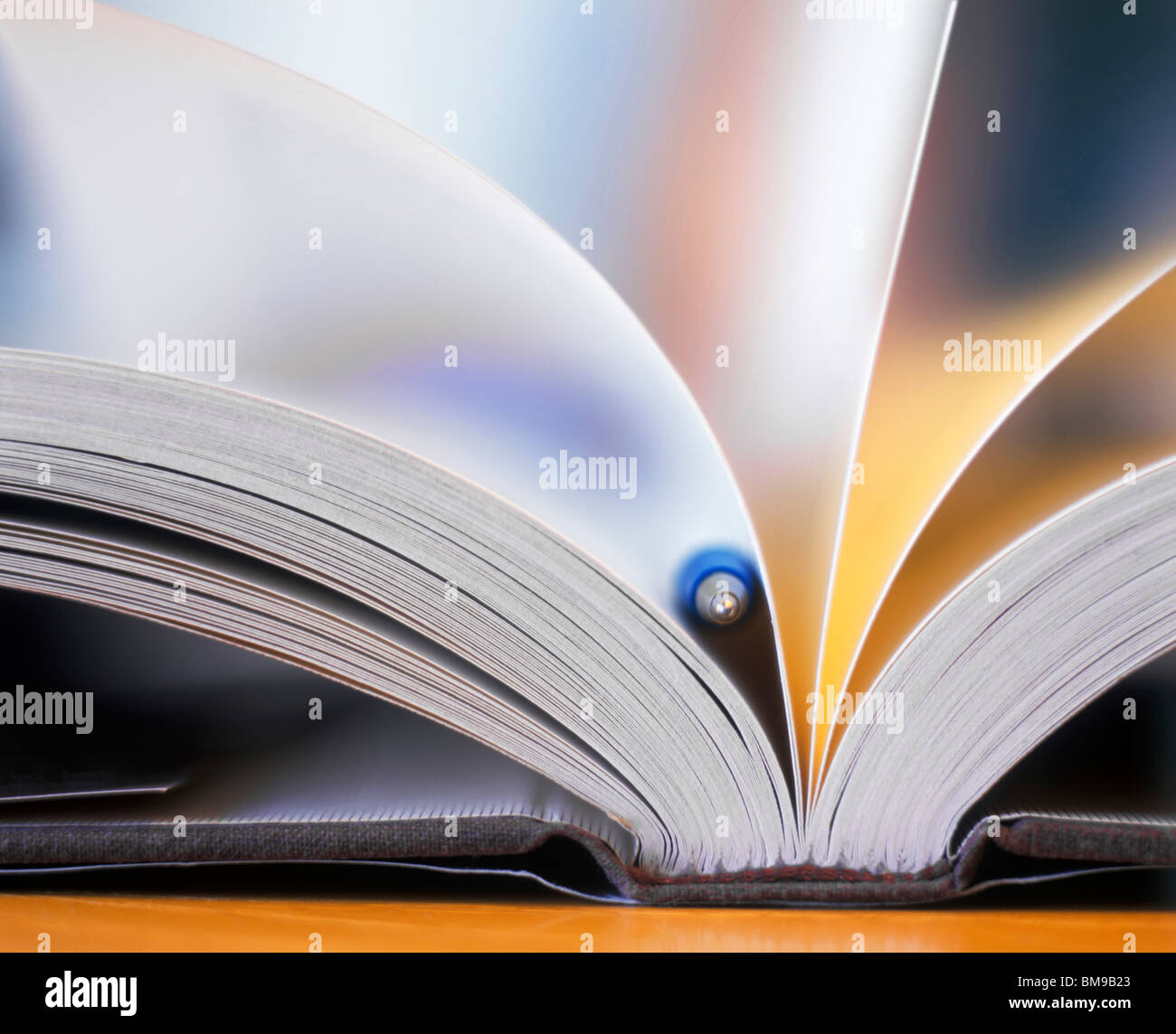 Still-life, An Open, fanned book with pen as Bookmark, close-up Stock Photo