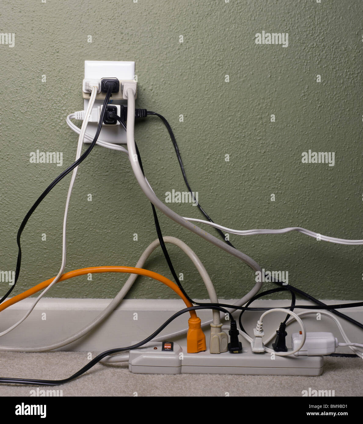 Multiple electrical plugs in overloaded wall outlet Stock Photo