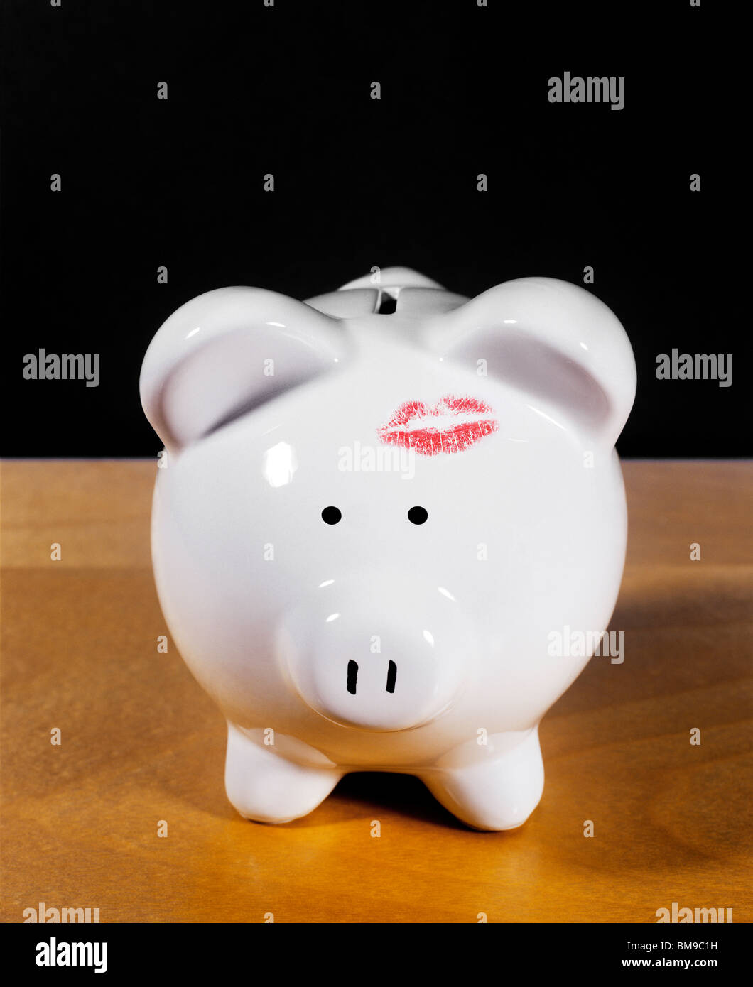 Still-life of a Piggy or coin savings Bank with lipstick kiss Stock Photo