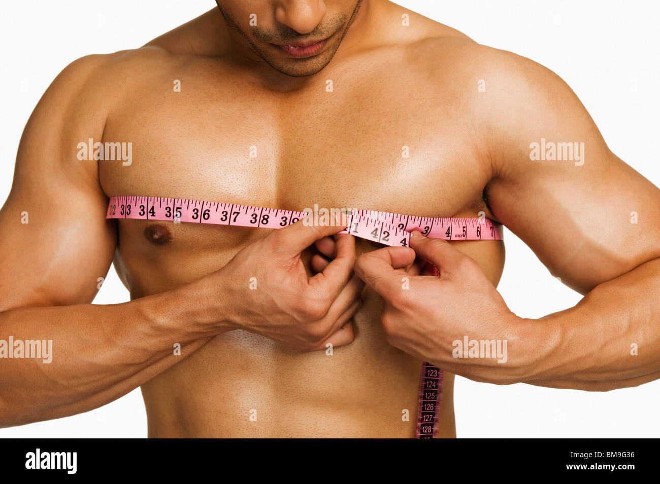 Close-up of a man measuring his chest with a tape measure Stock