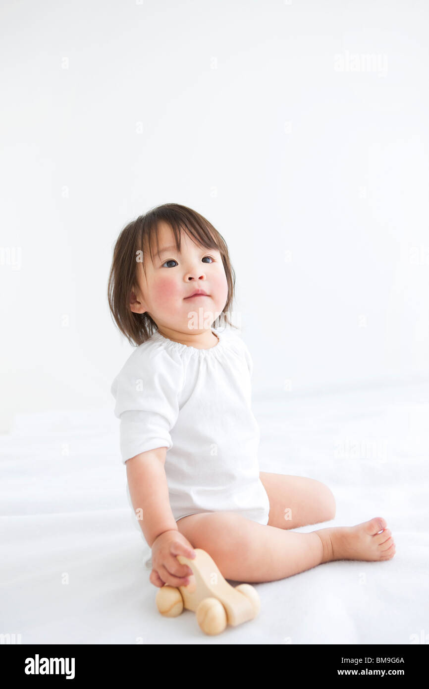 Baby girl playing with wooden toy car Stock Photo - Alamy
