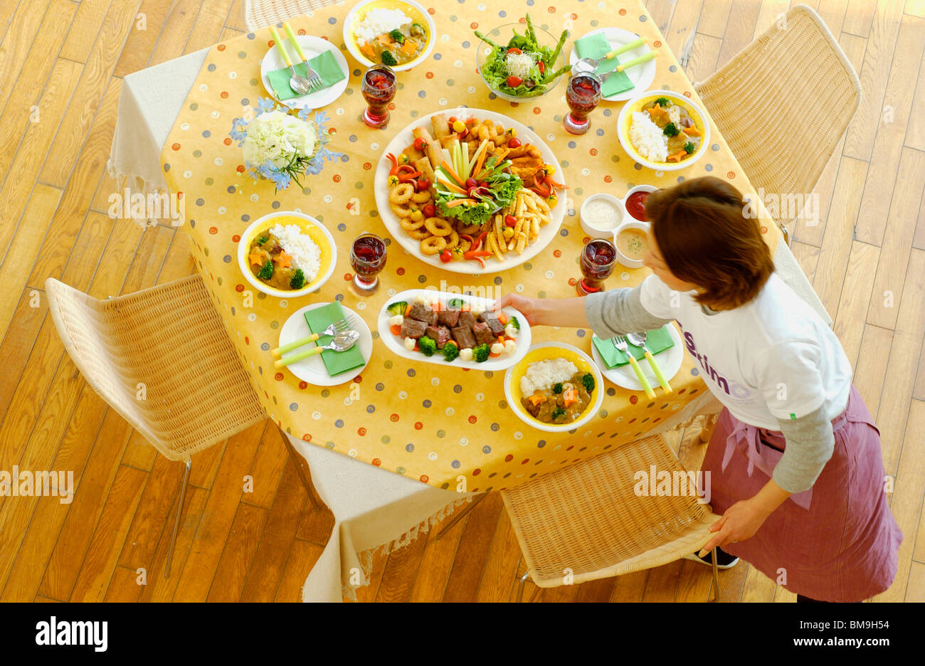 Woman serving dishes to dining table Stock Photo Alamy