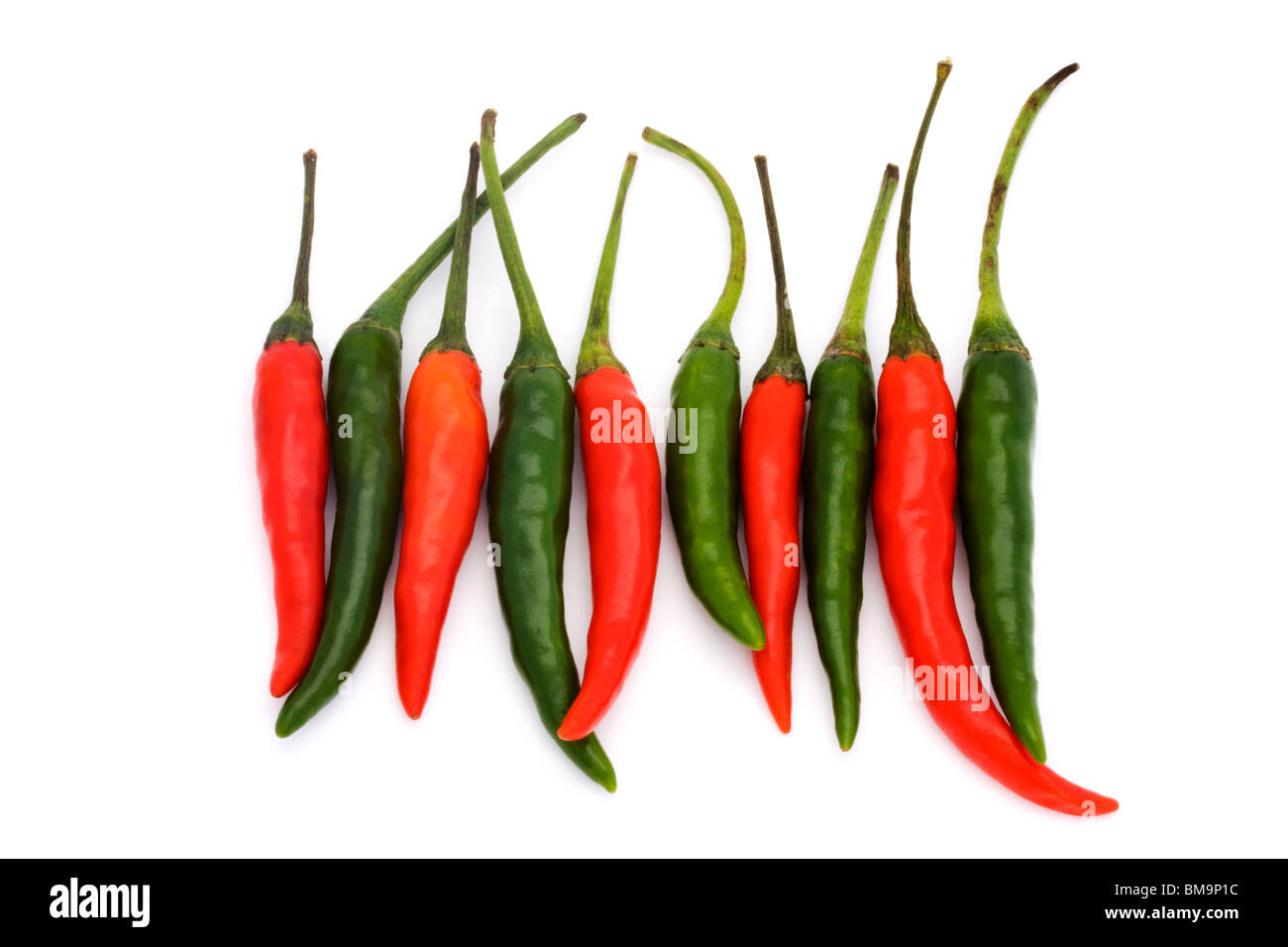 line of green and red chillies on a white background Stock Photo