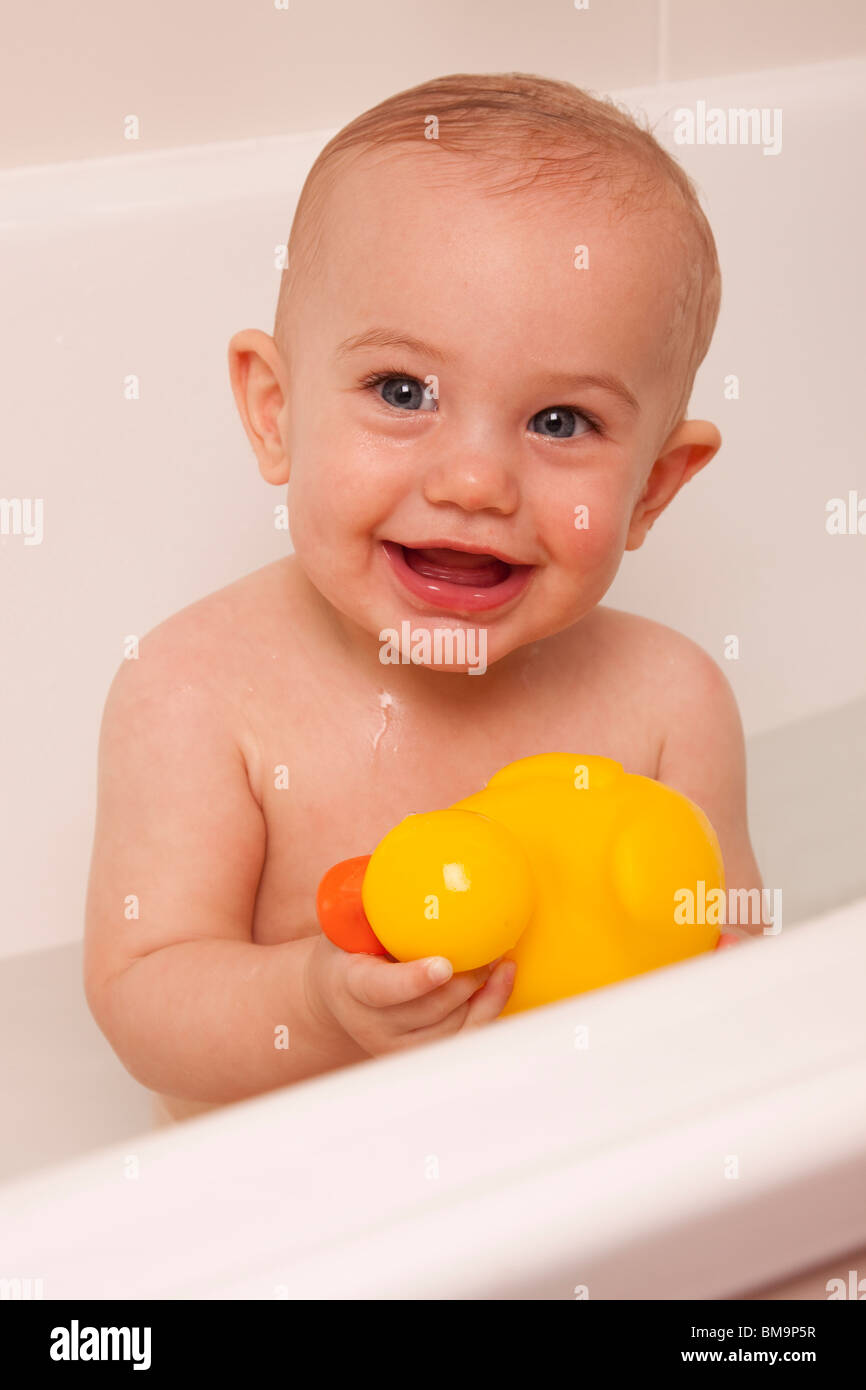 little baby playing in the bath with her yellow ducky Stock Photo Alamy