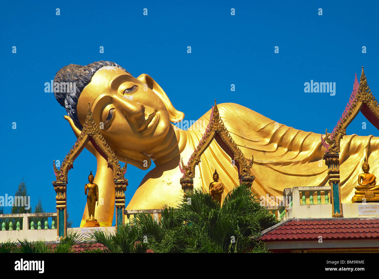 Head of a large gold reclining Buddha at Wat Sri Sunthon, a Buddhist temple on the island of Phuket Stock Photo