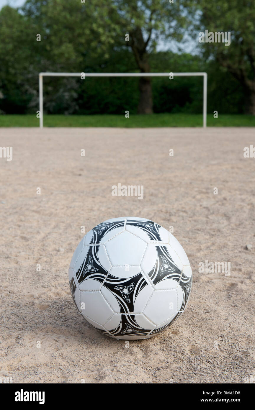 Football on sand pitch with goalposts in the background Stock Photo