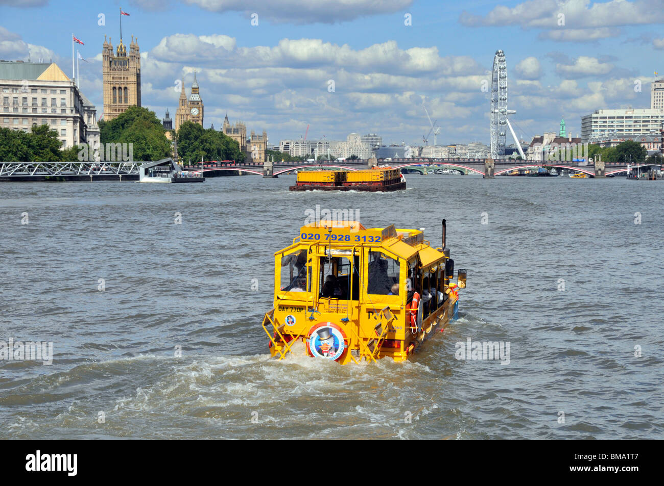 London UK business Duck Tours amphibious transport yellow sightseeing tour boat for tourist travel on River Thames to Westminster Bridge & London Eye Stock Photo