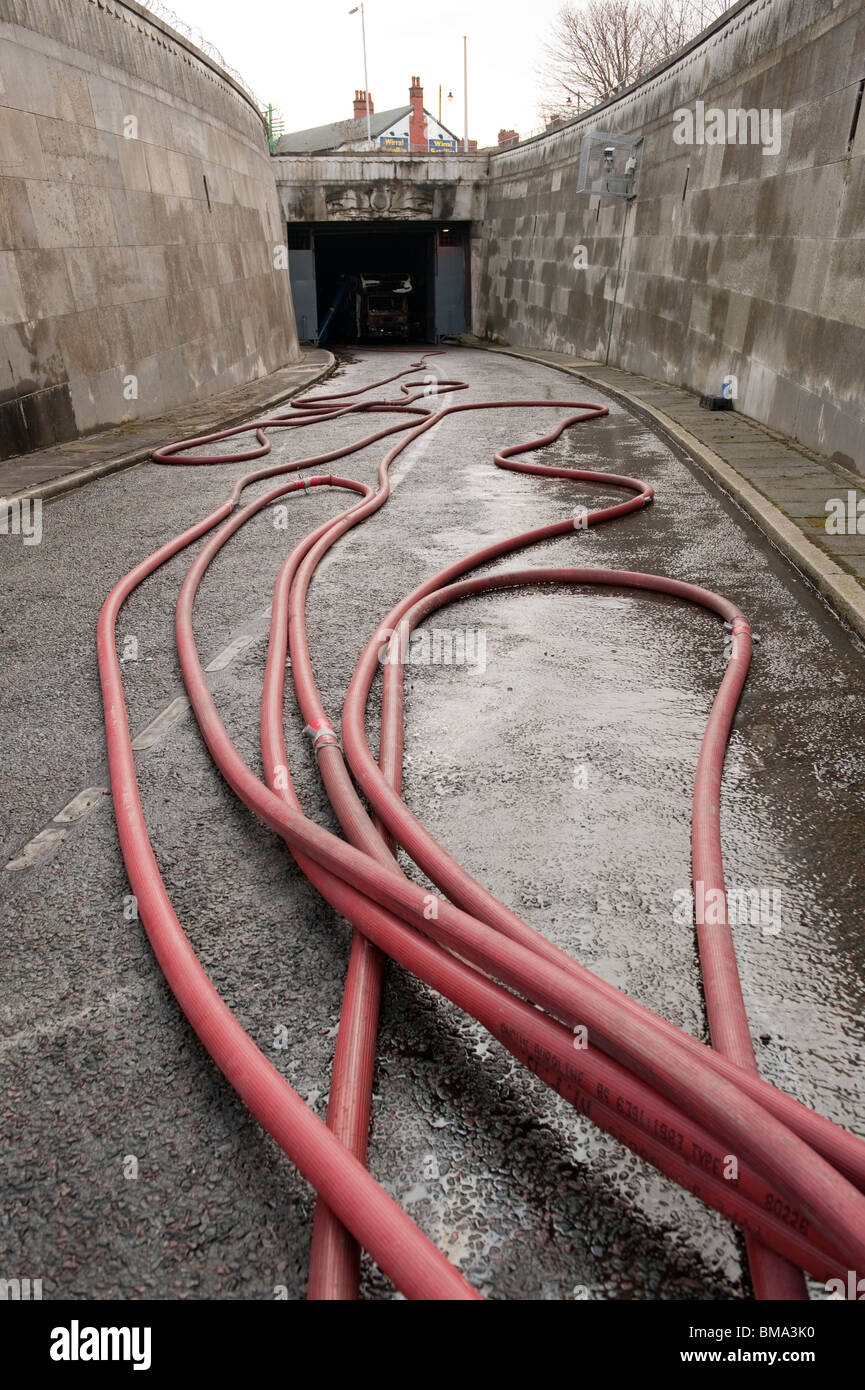 Fire hose entering underground road tunnel fire Stock Photo