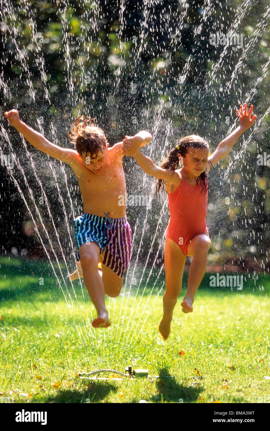 Jumping Through Lawn Sprinkler Jumping Through Lawn Sprinkler Stock Photo 29726084