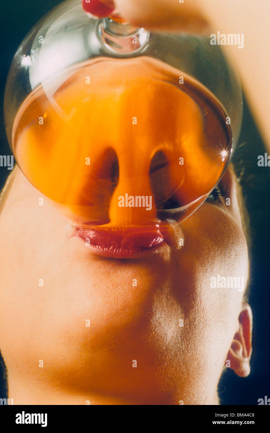 Nose distorted by the glass and liquid in drink. Stock Photo