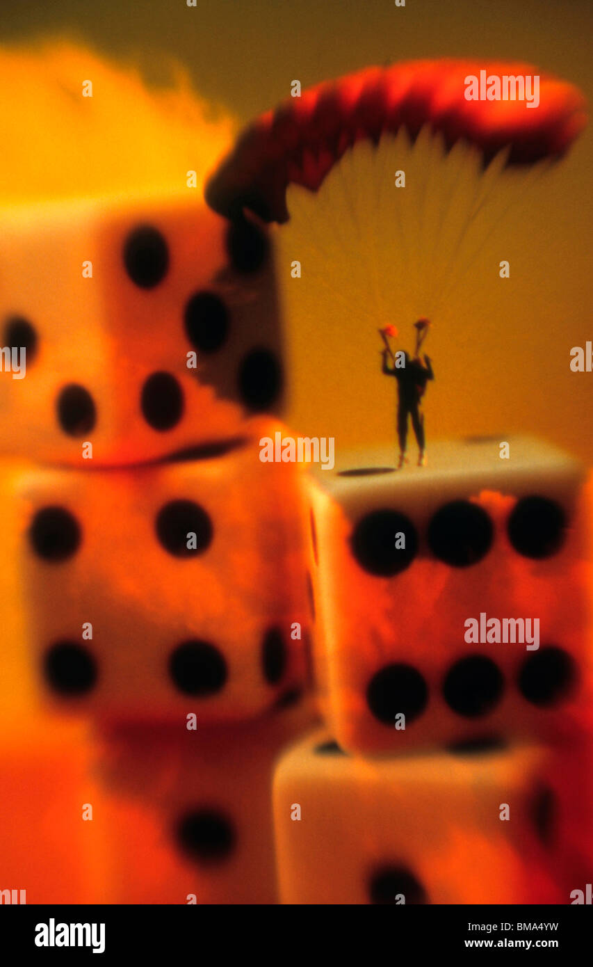 Man parchutes onto stack of dice. Stock Photo