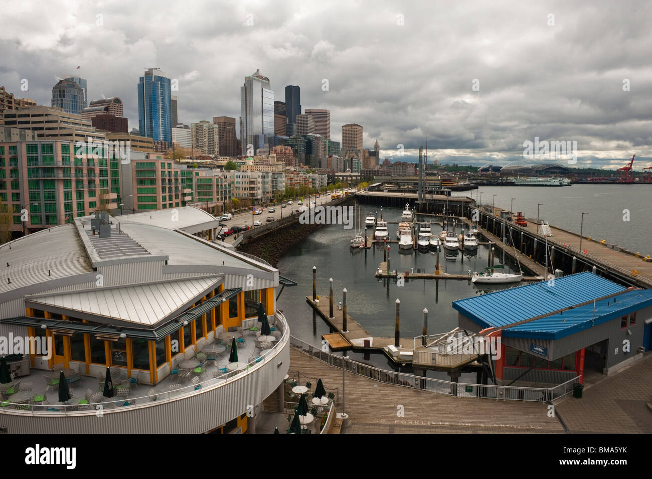 The dramatic Seattle, Washington skyline as seen from pier 66 on the Elliott Bay waterfront. Marinas, restaurants on waterfront. Stock Photo