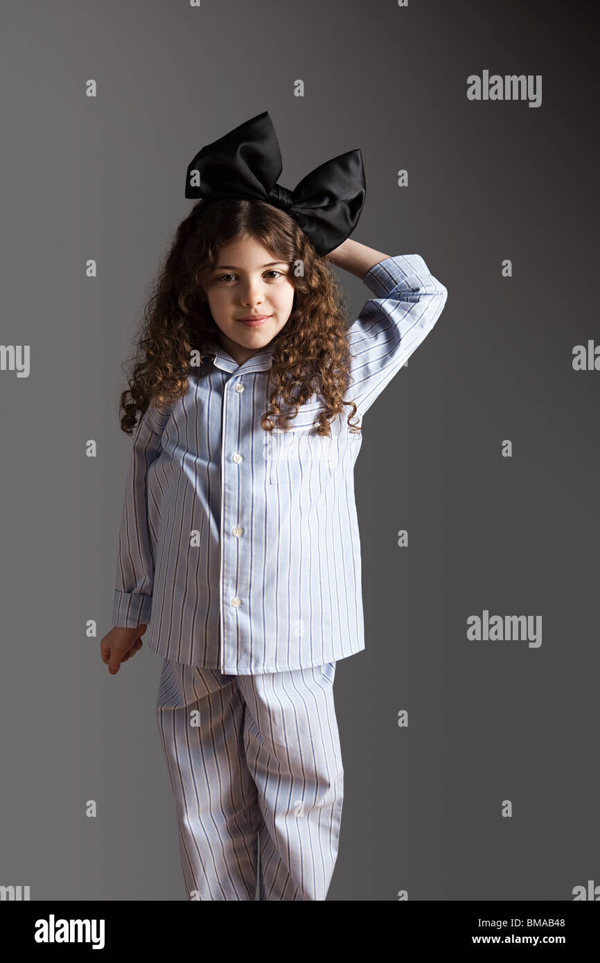 Young girl dressed in pyjamas with black hair bow Stock Photo