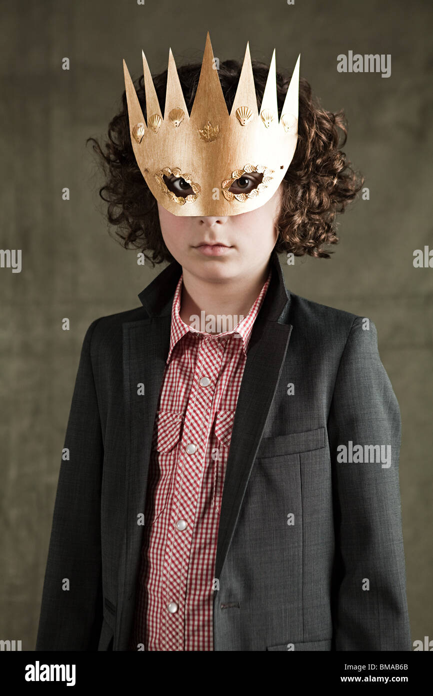 Young boy wearing gold crown mask Stock Photo
