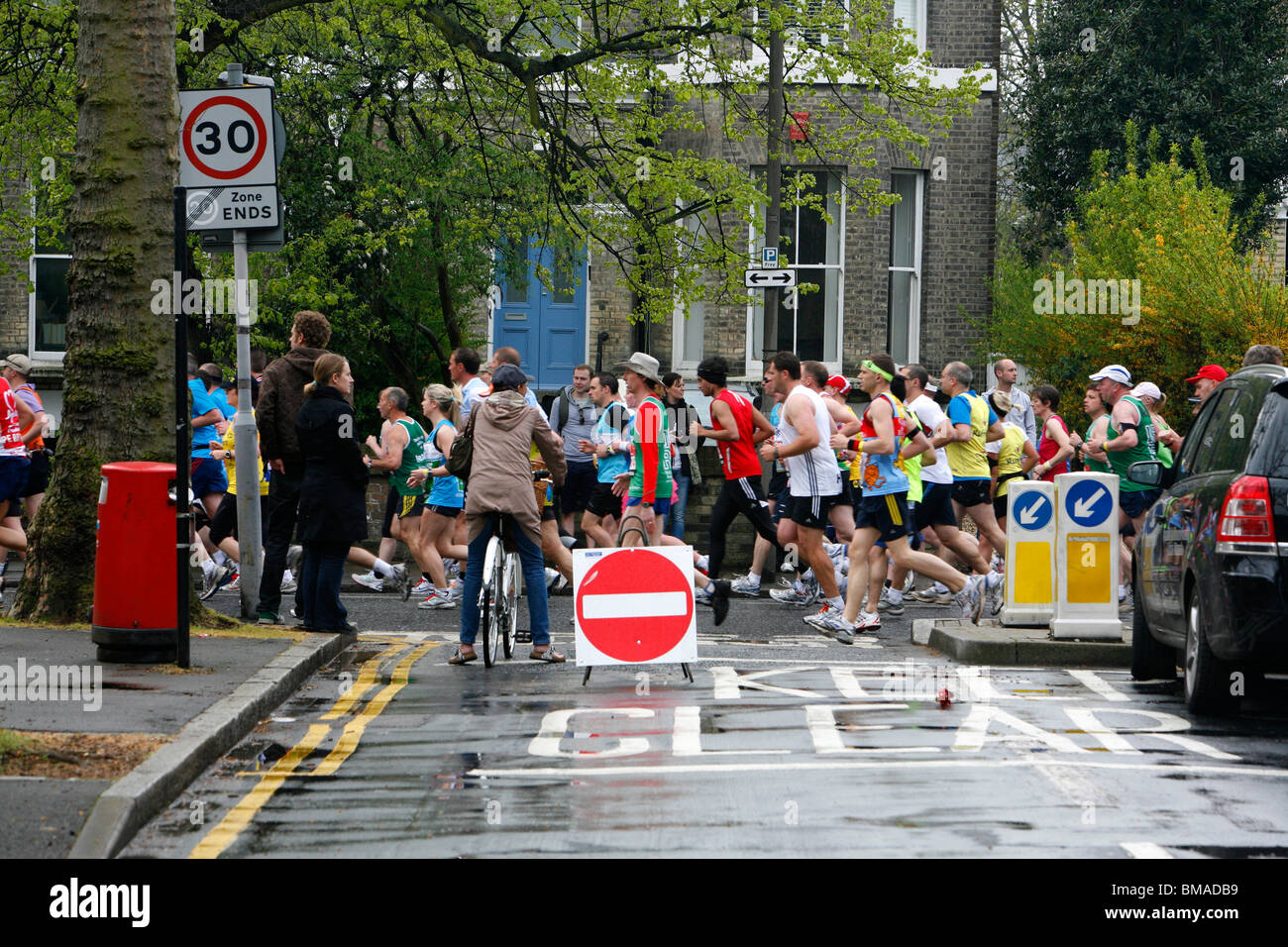 London Marathon runners running along Vanbrugh Park, Blackheath, London, UK. Taken from Mycenae Road. Stock Photo