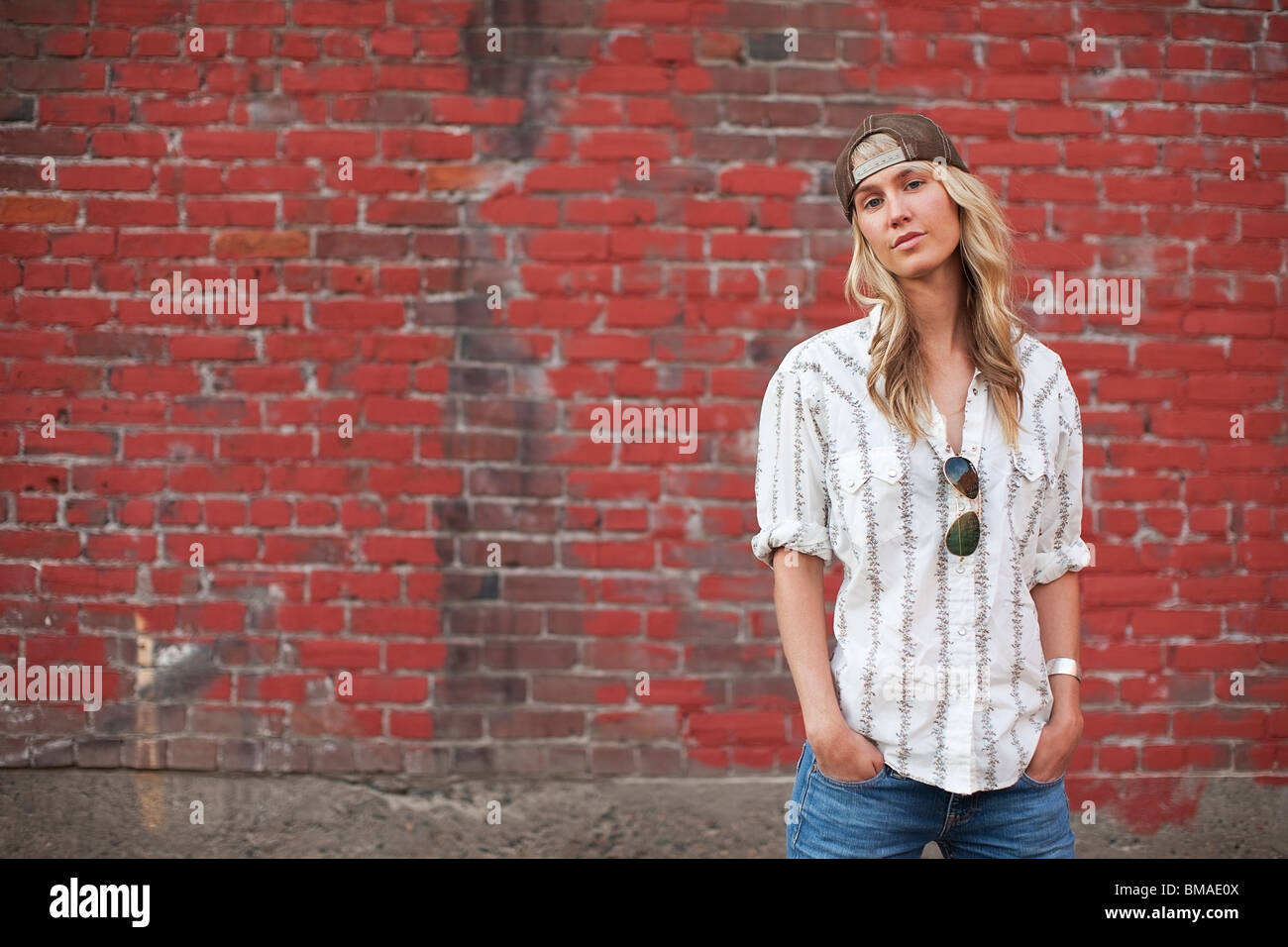 Portrait of Woman Standing in Front of Brick Wall Stock Photo - Alamy