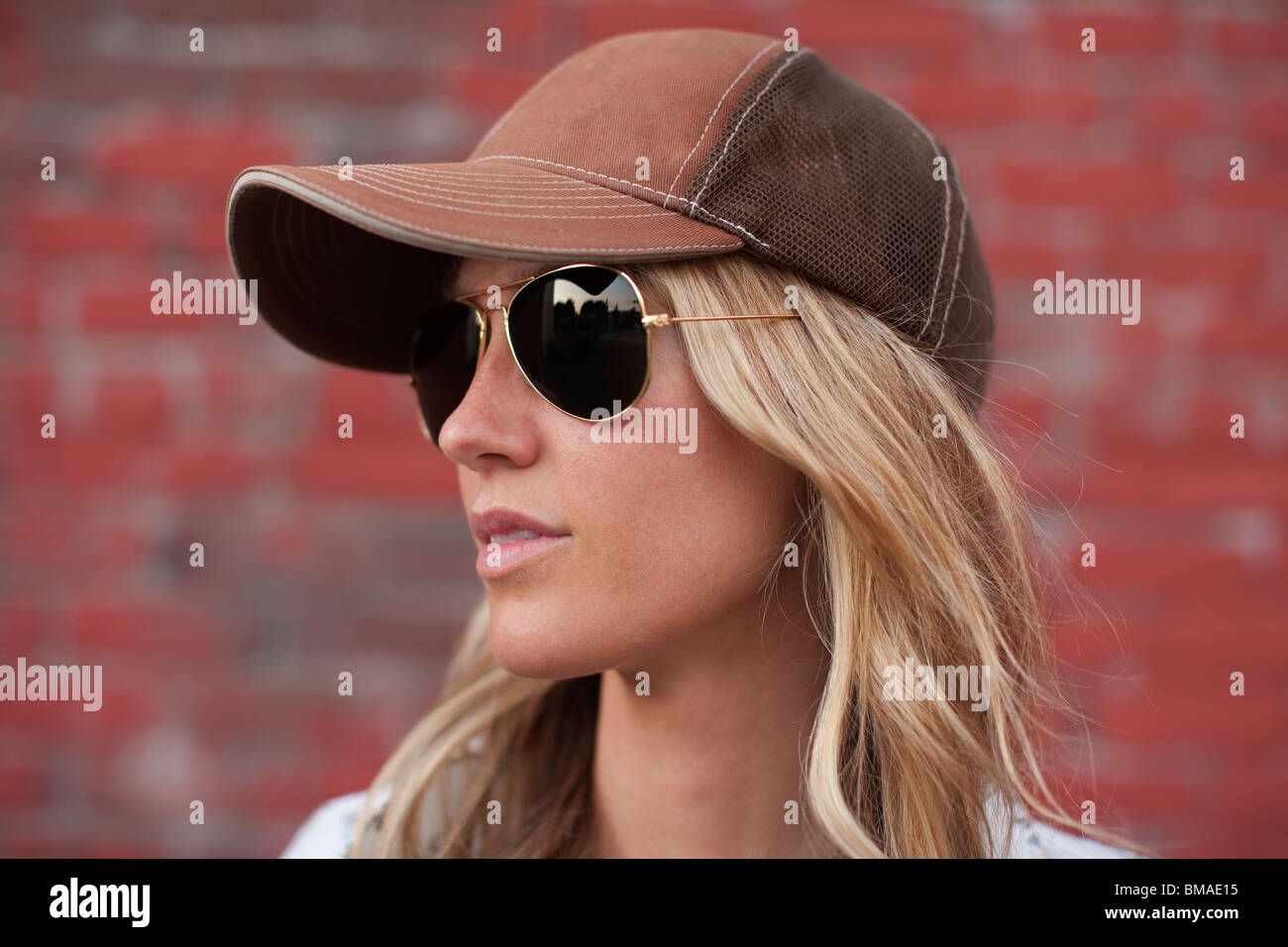 Close-up Portrait of Woman Standing in Front of Brick Wall Stock Photo ...
