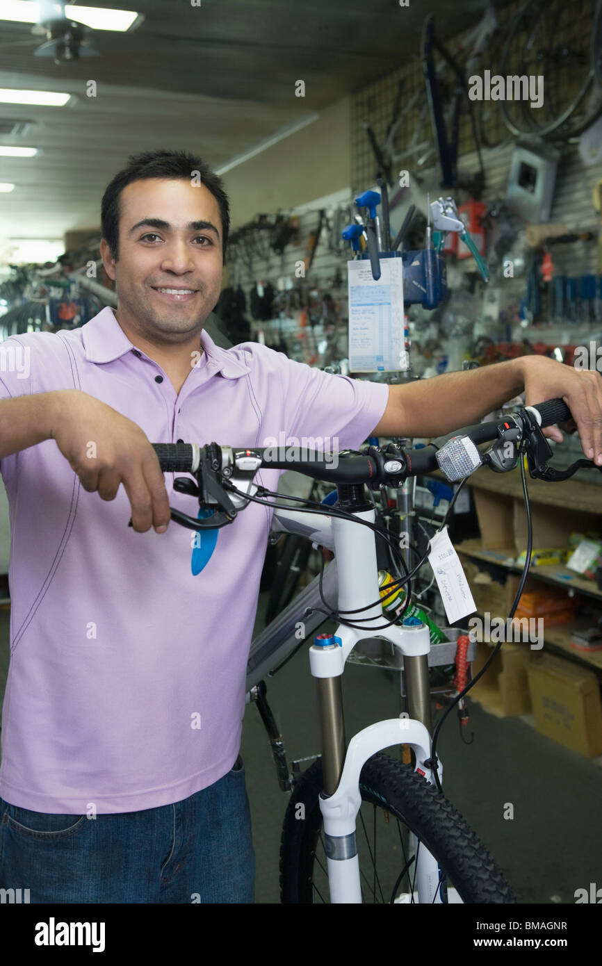 Bike shop assistant stands holding new bike Stock Photo Alamy
