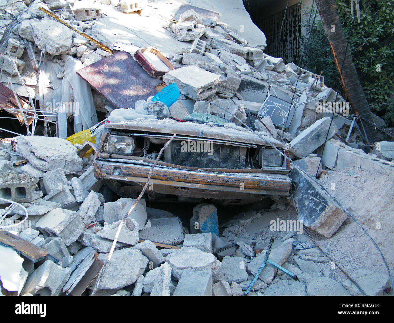 A car lies buried in rubble in central Port au Prince after the earthquake in Haiti Stock Photo