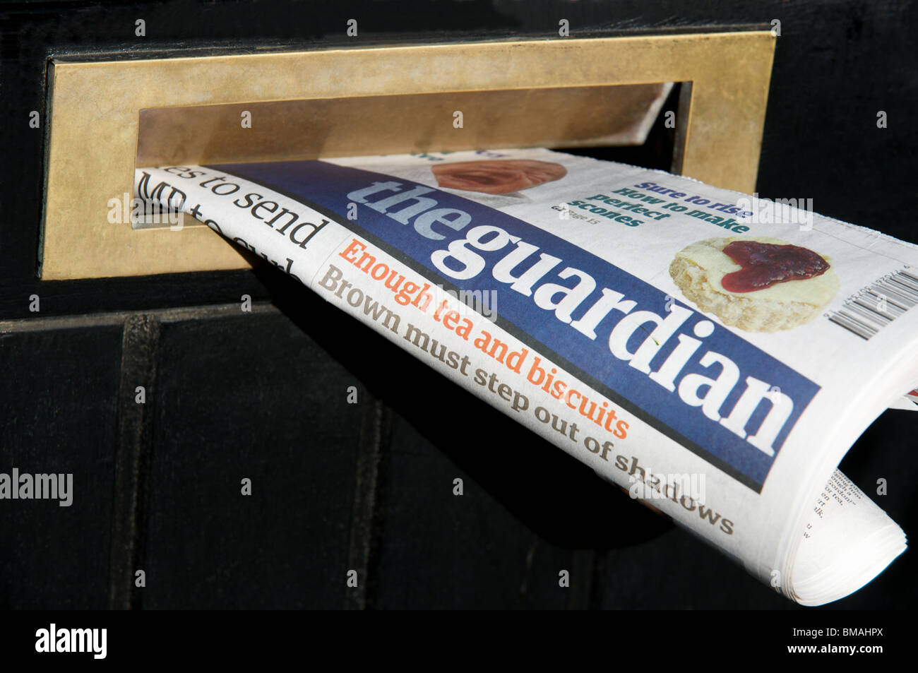 Guardian newspaper in letterbox, Bawdsey, Suffolk, UK. Stock Photo