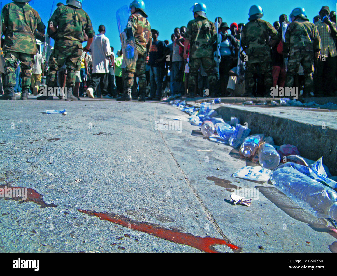 Blood dries on the street outside an aid centre in Port au Prince as UN peacekeepers hold back crowds after the Haiti earthquake Stock Photo