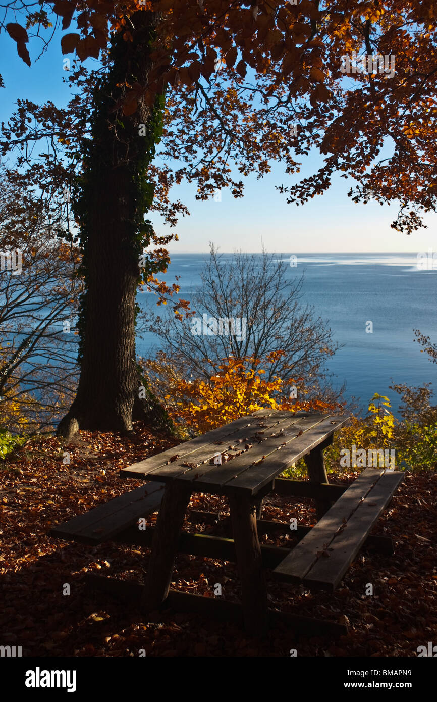 Picnic table in early morning light with view over the sea Stock Photo