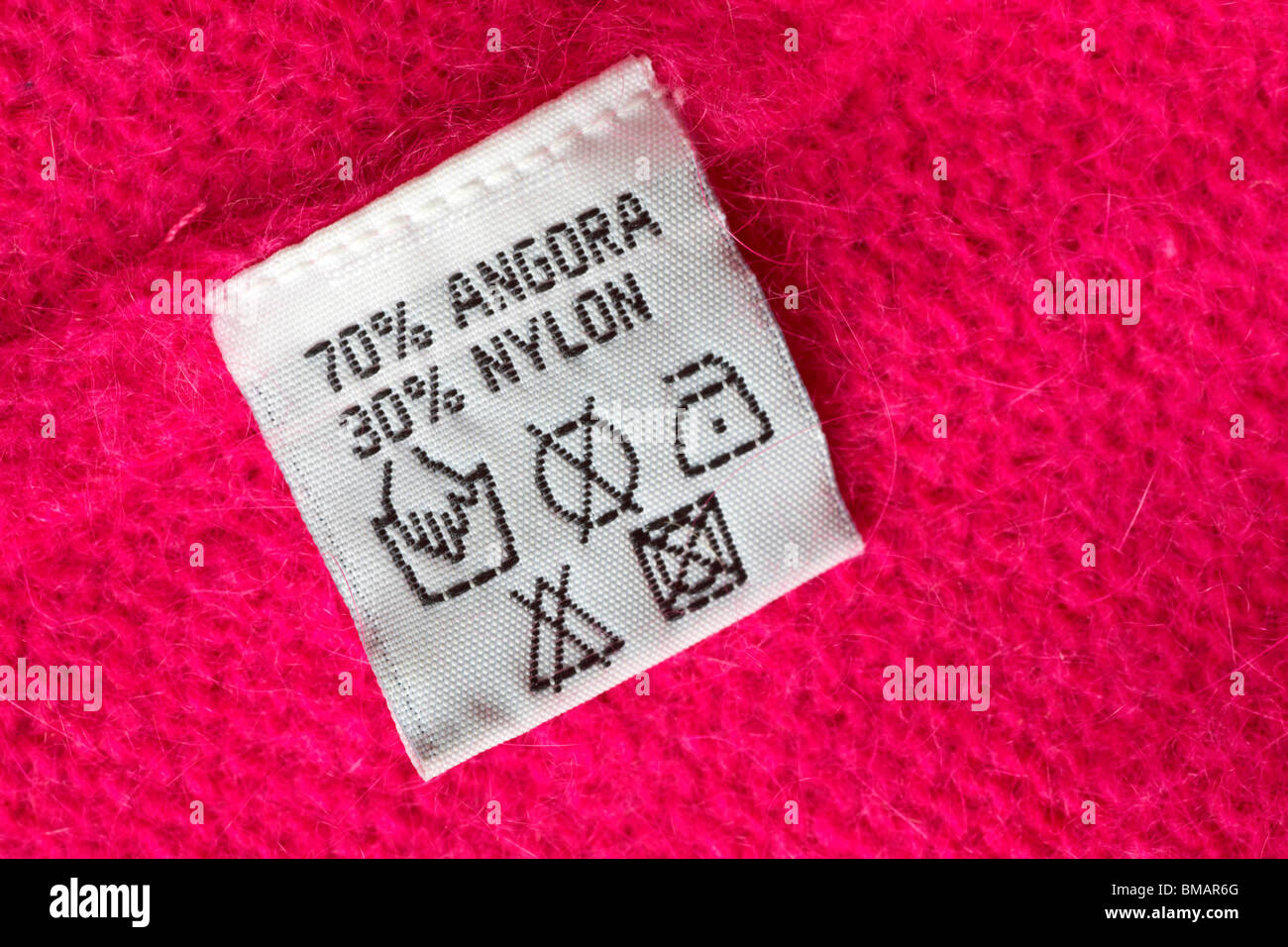 care label in pink jumper made up of 70% angora and 30% nylon Stock ...