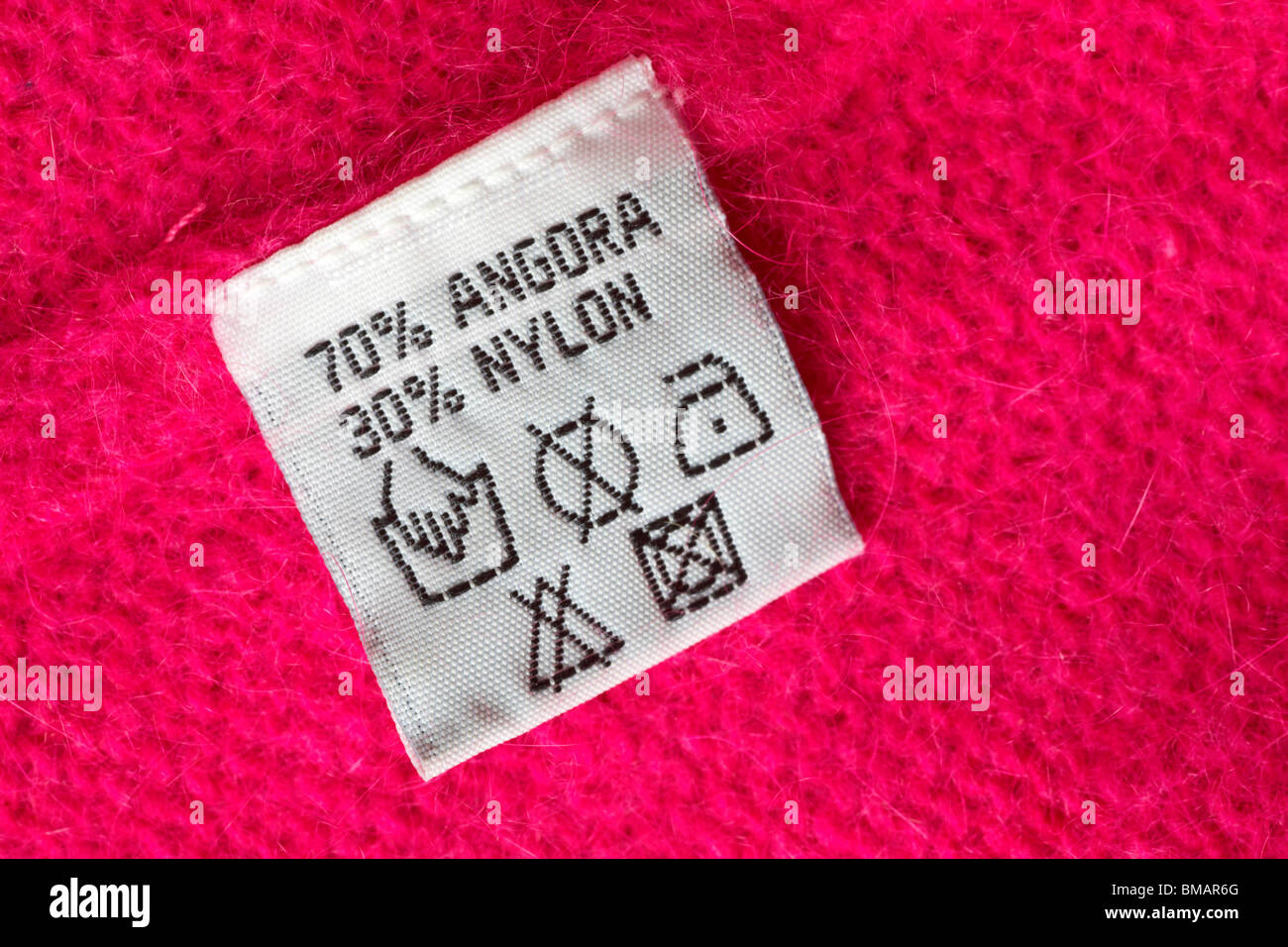 care label in pink jumper made up of 70 angora and 30 nylon Stock