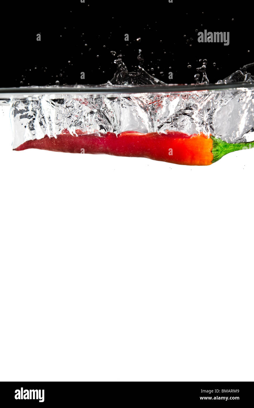 one red chili thrown in water with black and white background Stock Photo