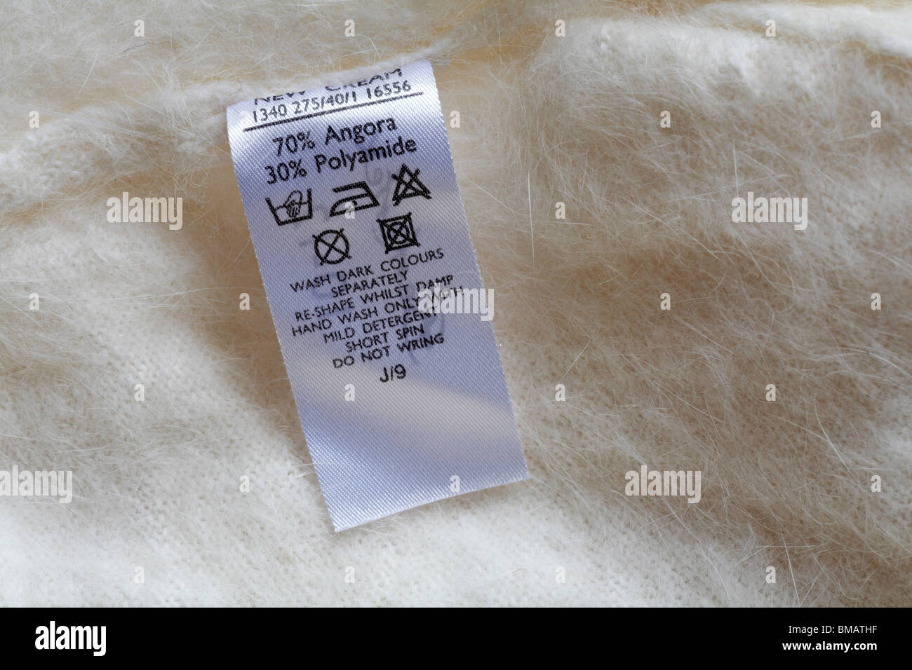 care label in cream jumper made up of 70% angora and 30% polyamide - care  washing symbols and instructions Stock Photo - Alamy