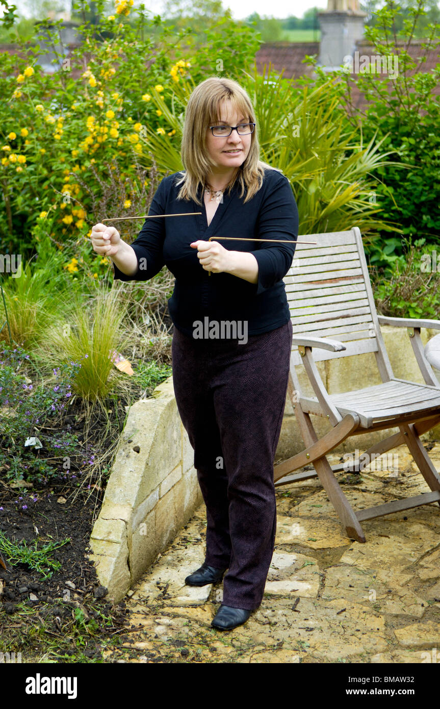 A woman using copper Dowsing rods which are used to find water sources