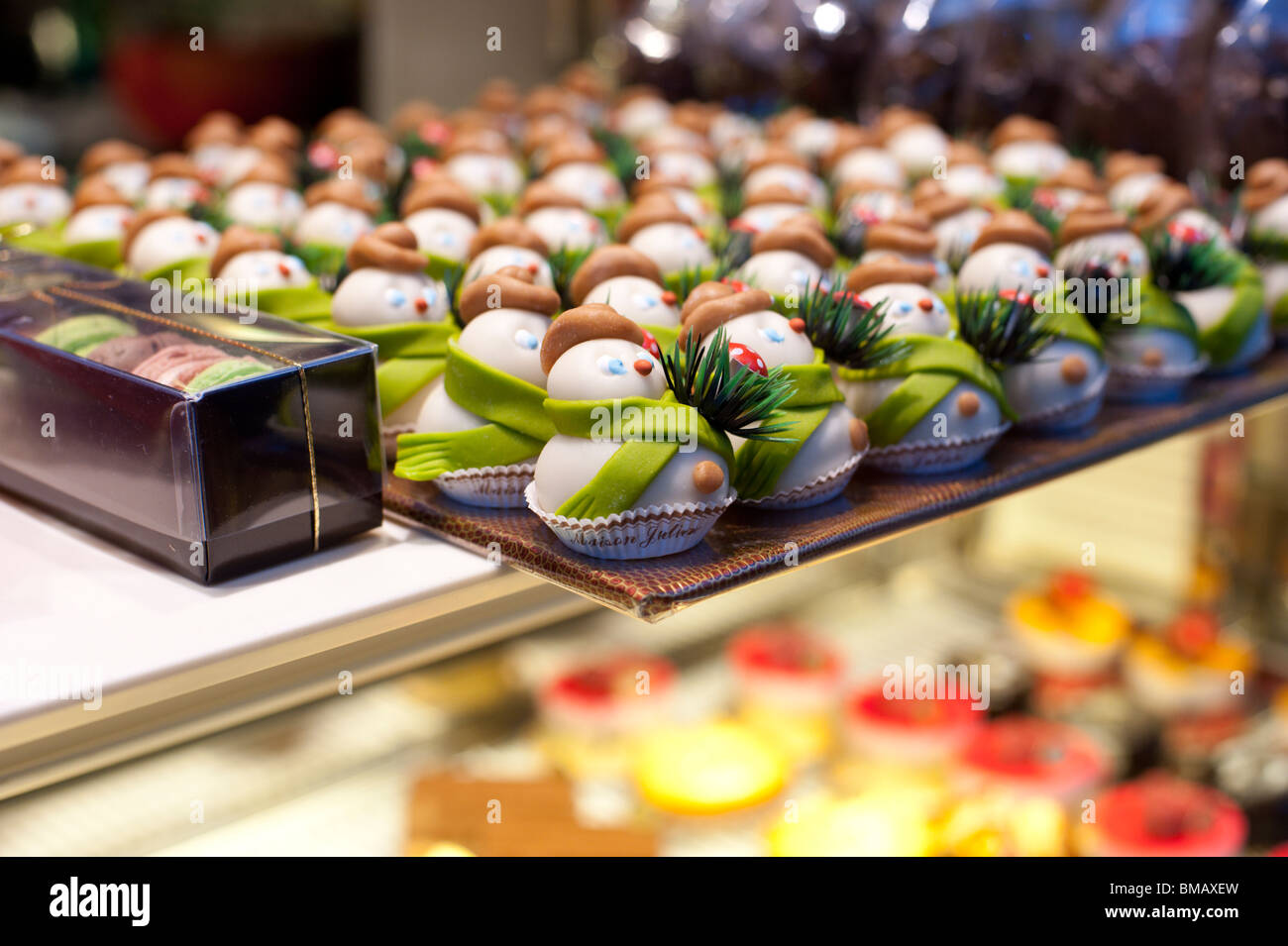 Confections in the shape of snowmen fill a glass display case at a Paris cake shop in December. Stock Photo