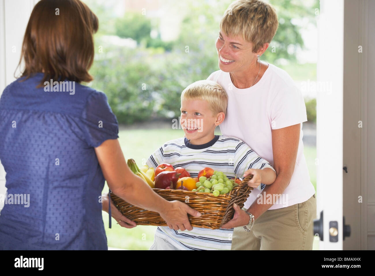 A Boy And His Mother Giving A Basket Of Fruit Stock Photo Alamy