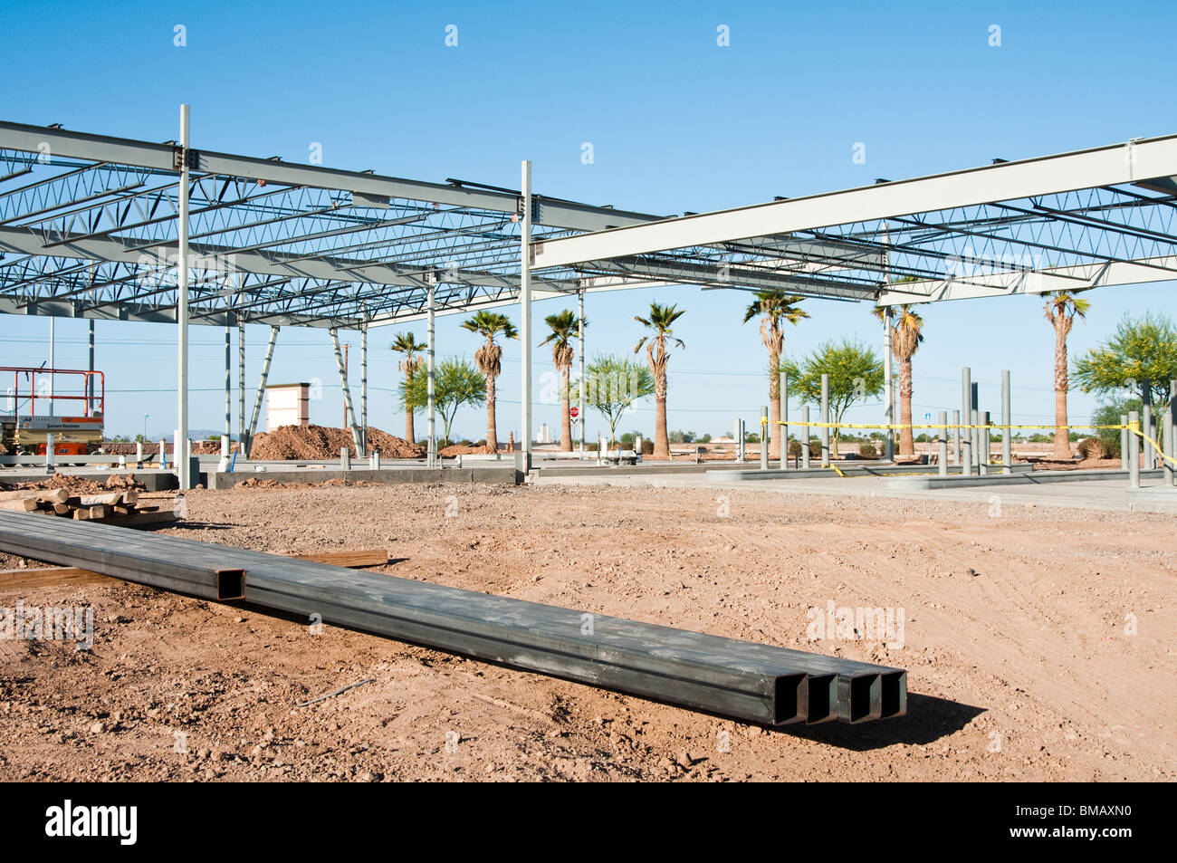 the structural steel skeleton of a new commercial building with square steel beams in the foreground Stock Photo