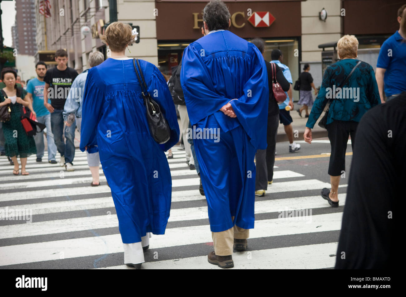 People wearing graduation gowns cross a street in midtown in New York on Thursday, May 27, 2010.(© Frances M. Roberts) Stock Photo